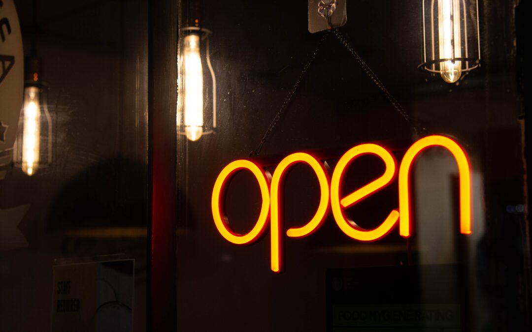OPEN neon sign and lamps glow yellow on a darker background